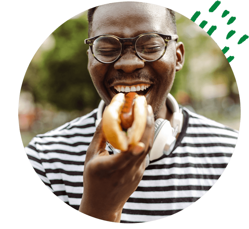 Guy eating a hot dog with a Garcia Sausage.